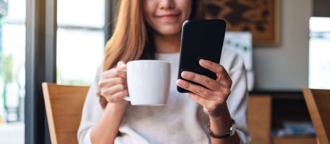 Vrouw drinkt kopje koffie en vult tegelijkertijd een betaalde enquête in